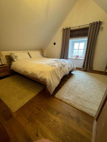 a bedroom with a bed and a window and rug at The little Stone House in Blankenheim