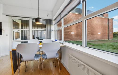 een kamer met een tafel, stoelen en ramen bij Fanø Bad, Lejl 12 in Fanø