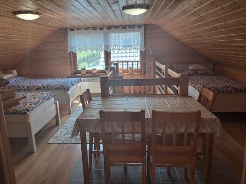 a dining room with a table and chairs in a cabin at Drewniany Domek Daria i Tomek 2 domki na 8 osób in Stronie Śląskie