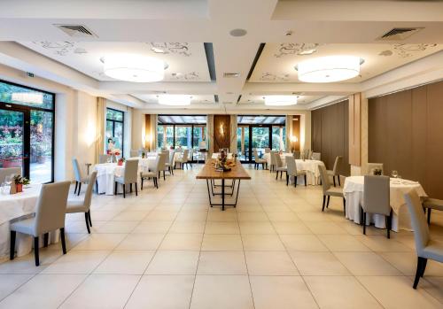 a dining room with white tables and chairs at Il Castagneto Hotel in Melfi