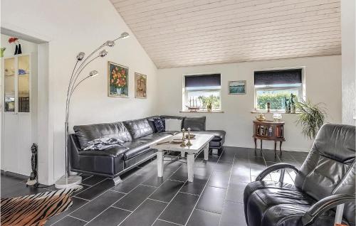 a living room with leather furniture and a table at Four-Bedroom Holiday Home In Storvorde in Storvorde