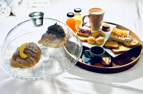 Una mesa con una bandeja de pasteles y un plato de comida. en Roma d'Amore, en Roma
