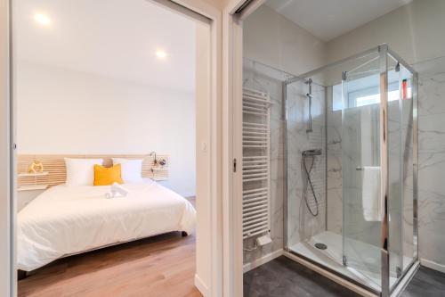 une chambre avec un lit et une douche en verre dans l'établissement Le cantonnement Angoumois, à Angoulême