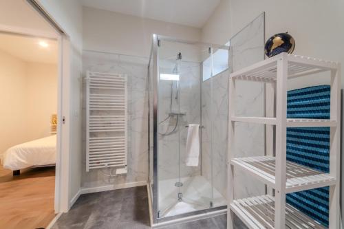 une salle de bain avec une douche avec une porte vitrée dans l'établissement Le cantonnement Angoumois, à Angoulême