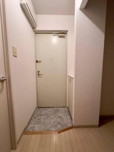 an empty hallway with a white door in a room at 411札幌駅7分と大通駅徒歩6分で好立地な都心を満喫でき綺麗な部屋で快適が生活が実現 in Sapporo