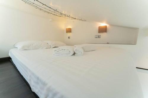 - une chambre blanche avec un grand lit blanc et 2 serviettes dans l'établissement SK Joli Studio, Le Port, Clim, Tramway, Wifi 17 BONAPARTE, à Nice