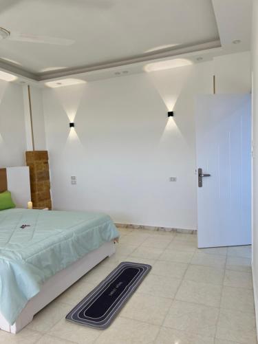 ein Schlafzimmer mit einem Bett, einer Tür und einem Teppich in der Unterkunft Kite and Dive Home in Hurghada