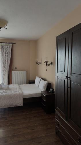 a bedroom with two beds and a dresser and a cabinet at Guesthouse Kastro in Edessa