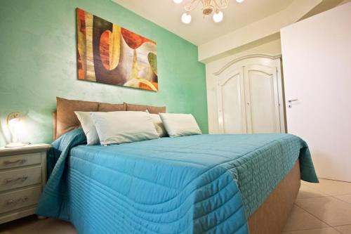 ein Schlafzimmer mit einem blauen Bett mit blauer Decke in der Unterkunft Villa Panoramica 5 in Torre Pali 