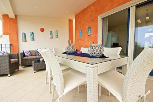 ein Esszimmer mit einem weißen Tisch und Stühlen in der Unterkunft Villa Panoramica 5 in Torre Pali 