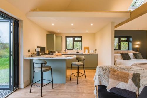 a bedroom with a bed and a kitchen with a counter at The Garden Room by Bloom Stays in Rye