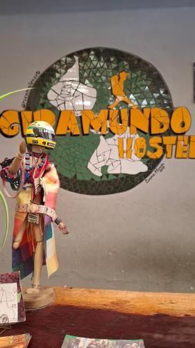 a doll sitting on a table in front of a sign at Giramundo Hostel in Humahuaca