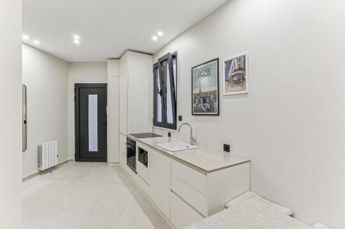 een witte badkamer met een wastafel en een spiegel bij Maison atypique de 82 m2 sur 4 niveaux proche Saint Mande in Vincennes