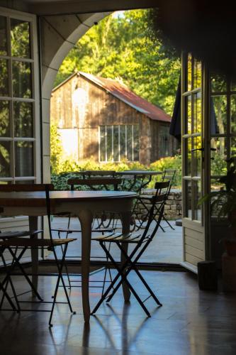 une terrasse avec une table et des chaises ainsi qu'une grange dans l'établissement Moulins de Clan, à Jaunay-Clan