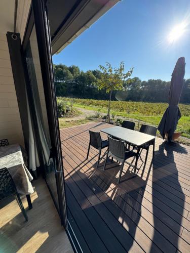 a patio with a table and chairs on a deck at Le Ponant in Vaison-la-Romaine