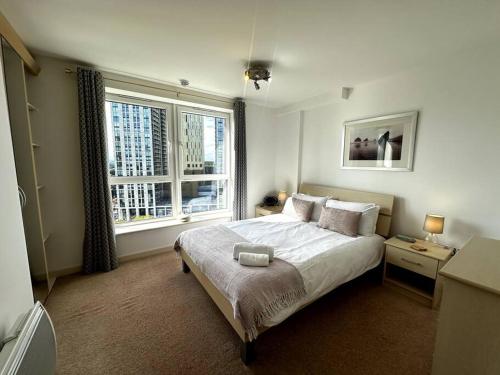 a bedroom with a bed and a large window at Woking Town Centre - Parking Included by Deilamy Homes in Woking