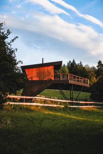 a building with a bridge in the middle of a field at Treedom in Prievidza