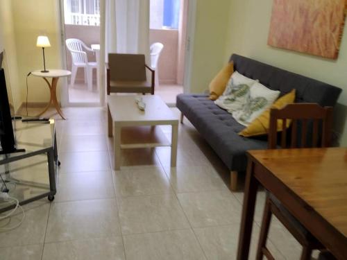 a living room with a blue couch and a table at 1A Apartment Abrigos, Wifi and balcony in Los Abrigos