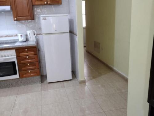 a kitchen with a white refrigerator in a room at 1A Apartment Abrigos, Wifi and balcony in Los Abrigos