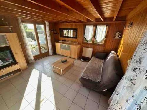 a living room with a couch and a tv at Chalet douillet 4 personnes -Proche plage in Merville-Franceville-Plage