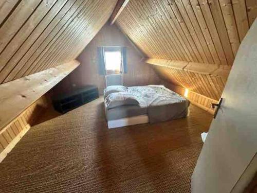 une chambre avec un lit dans un grenier dans l'établissement Chalet douillet 4 personnes -Proche plage, à Merville-Franceville-Plage
