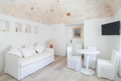 a white living room with a white couch and a table at Borgofreddo Luxury Suite in Monopoli