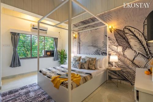 a bedroom with a four poster bed in a room at EKOSTAY - Amanta Palms 6BHK in Karjat