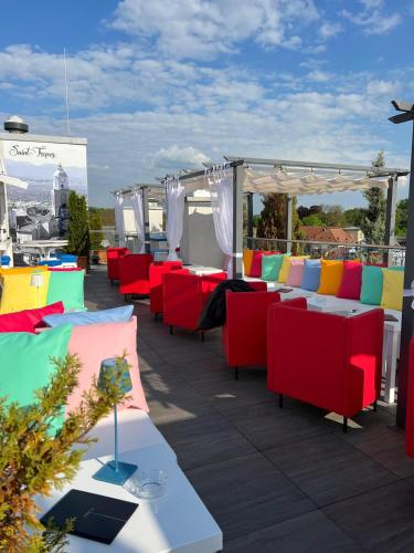 a patio with colorful chairs and tables on a roof at Grande Albergo Giancarlo in Weimar