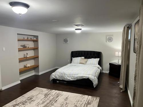 a bedroom with a bed with a black headboard at Home by Dolly in Toronto