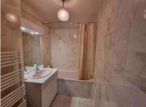 une salle de bain avec un lavabo et une baignoire dans l'établissement Athena Proche plage Centre cabourg, à Cabourg