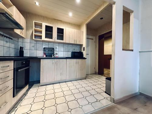 a kitchen with wooden cabinets and a tiled floor at sleepWELL-Steinfurt II Zentral Burgsteinfurt in Steinfurt