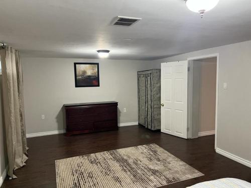 an empty living room with a dresser and a door at Home by Dolly in Toronto