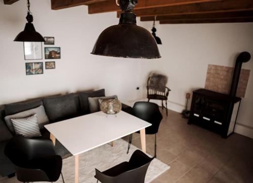 a living room with a white table and black chairs at Freistehendes 4-Sterne Ferienhaus in der Uckermark in Haßleben