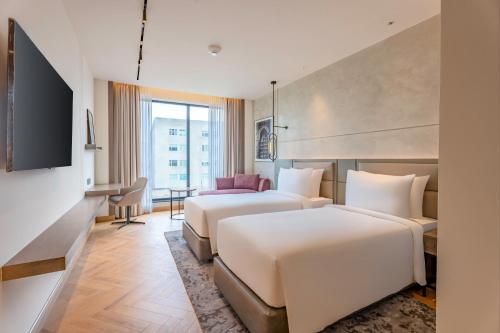 a hotel room with two beds and a television at Park Inn by Radisson Jalandhar in Jalandhar