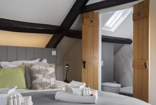 a bedroom with a bed with towels on it at Spring Cottage in Painswick