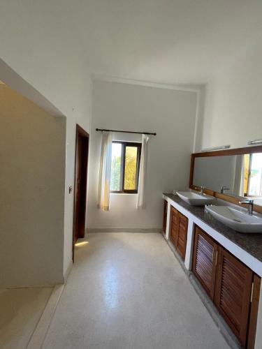 a bathroom with two sinks and a large mirror at Mawe Zuri Resort in Watamu