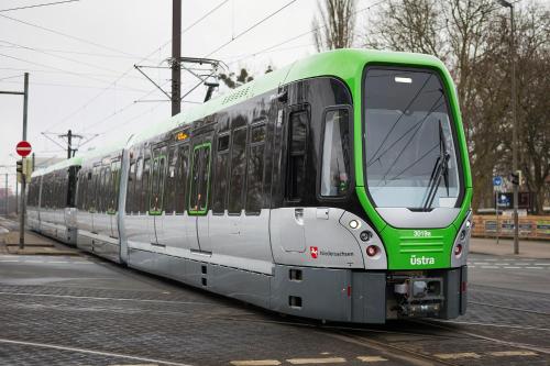 a green and white train on a street at Hannover - PHIL & MAX Hotels und Apartments Messe in Hannover