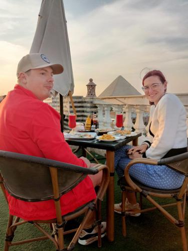 カイロにあるStar Of Egypt Pyramidsのワイングラスを飲みながら座る男女