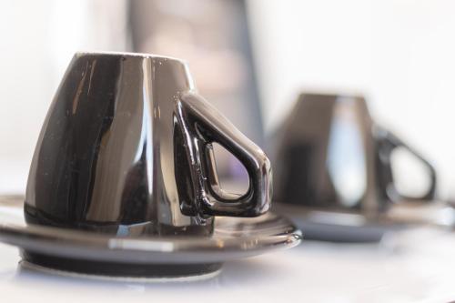 a black coffee cup sitting on top of a table at High Beach Resort in Malia