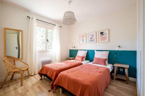 - une chambre avec 2 lits avec des draps orange dans l'établissement Villa Dahlia à deux pas de la plage PYLA SUR MER, à La Teste-de-Buch