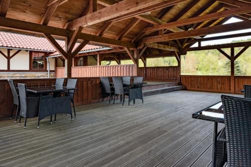 a wooden deck with chairs and a table on it at Hotel Švýcarský dům in Sněžnik