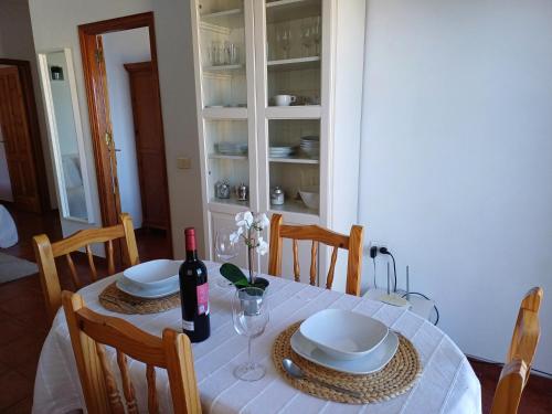 a dining room table with a bottle of wine and glasses at Vv - Casa Clary -Finca Medina in Alojera