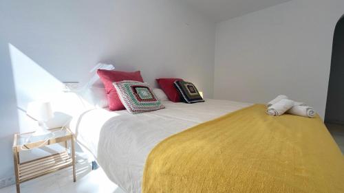 a bedroom with a bed with colorful pillows on it at Mshome Sierra Nevada Monachil in Monachil