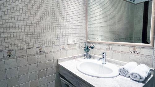 a bathroom with a sink and a mirror and towels at Mshome Sierra Nevada Monachil in Monachil