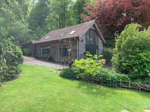 a small house in a yard with a garden at Woodside, surrounded by woodland and beautiful gardens in Wrington