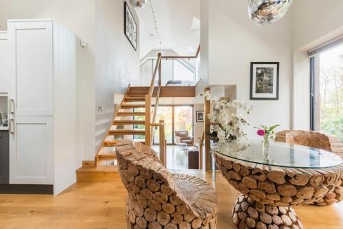 a living room with a glass table and chairs at Woodside, surrounded by woodland and beautiful gardens in Wrington