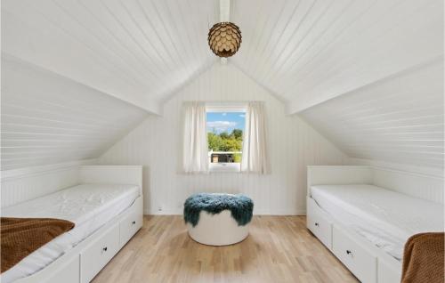 a white attic bedroom with two beds and a window at 2 Bedroom Amazing Home In Gilleleje in Gilleleje