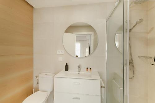 Un baño con inodoro, lavabo y espejo. en Teresita La Fuente, en Puerto de Mogán
