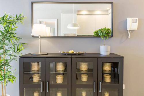 ein schwarzer Schrank mit einem Spiegel und einer Lampe in der Unterkunft Teresita Mogamar Beachfront in Puerto de Mogán