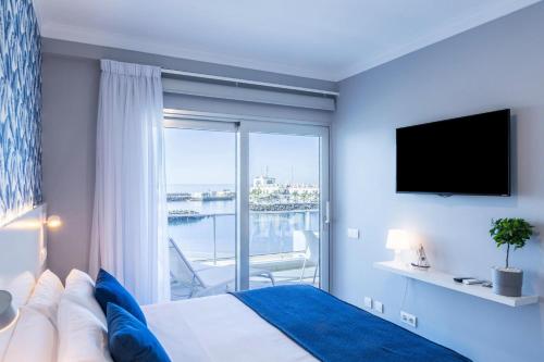 ein Schlafzimmer mit einem Bett und einem großen Fenster in der Unterkunft Teresita Mogamar Beachfront in Puerto de Mogán